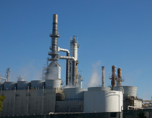 smokestacks and storage tanks of an oil refinery plant