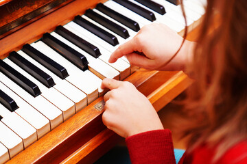 Top view of a hand. Small kid's hand on a piano keyboard. Education, child development concept....