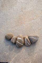 Fototapeta na wymiar Beautiful beige beach stones laid on slab stone. 
