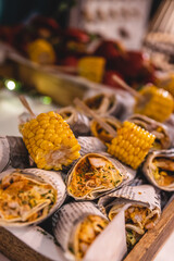 Chicken wraps and corn cobs on a plate stacked Mexican style