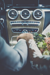 wedding couple holding hands in a car