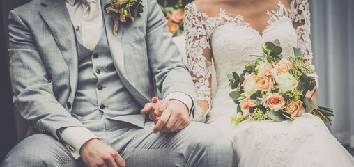 wedding couple holding hands and a bouquet of flowers