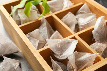 Fototapeta na wymiar Paper tea bags in wooden box on table, closeup