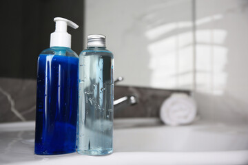 Bottles of shower gel on sink in bathroom. Space for text