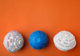 Laundry dryer balls on orange background, flat lay. Space for text