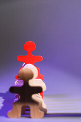 Wooden figures with red one on purple background, space for text. Recruiter searching employee