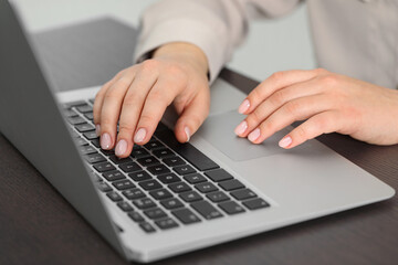 Fototapeta na wymiar Woman working on laptop at table, closeup. Electronic document management