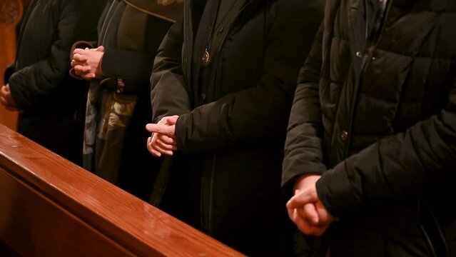 Nuns with hands crossed. Catholic nun praying with hands folded and fingers crossed. Christian woman praying in Cathedral. Christmas Midnight Mass in church. 