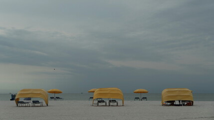 Long row of yellow beach cabanas and umbrellas  at Indian Shores beach
