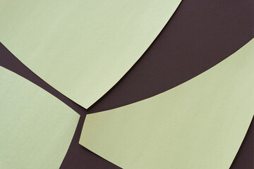 three cut paper shapes on a smooth brown paper background