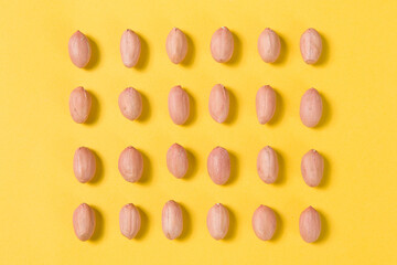 rows of  raw  peanuts  nuts repetition isolated on blue background