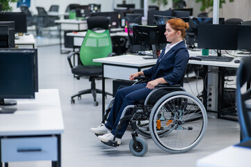 Caucasian woman wheelchair in open space office.