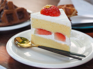 White cake with strawberries with gold leaf top of strawberry