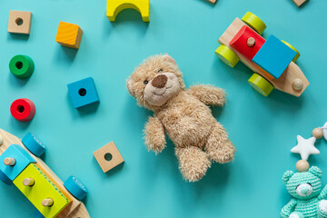 Teddy bear, wooden toys, blocks for preschooler children on a blue background.  Toys for kindergarten, preschool or daycare. Copy space for text. Top view