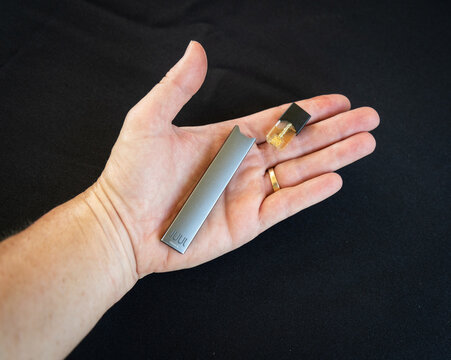 A hand holding an e-cigarette that was found at a high school graduation ceremony.  E-cigarettes  can look like USB drives and are very hard for school officials to spot.