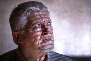 Portrait of an elderly man, he looks longingly into the light, the shadow of a lattice can be seen on his face