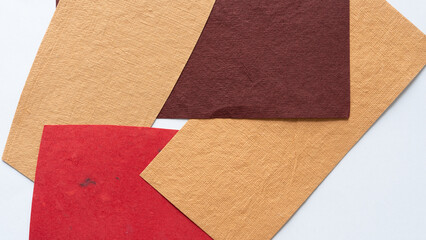 Fototapeta premium rough and textured brown yellow and red paper shapes background