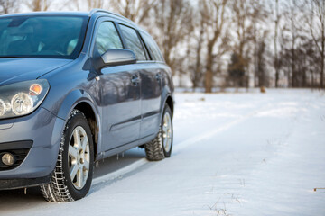 Car parked in snowy field on winter day.