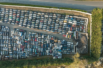 Aerial view of big parking lot of junkyard with rows of discarded broken cars. Recycling of old vehicles