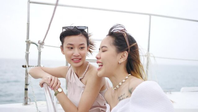 4K Young attractive Asian woman friends passenger tourist enjoy and fun luxury outdoor lifestyle travel on private catamaran boat yacht sailing in the ocean on summer holiday tropical beach vacation.