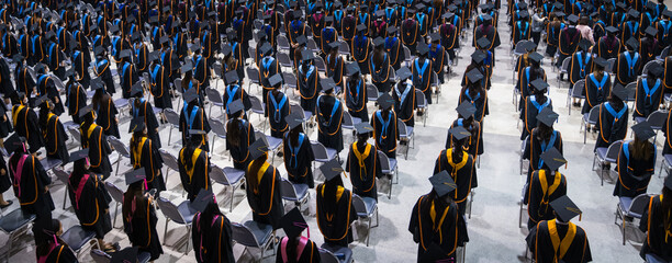 Rear view of the university graduates in graduation gowns and caps