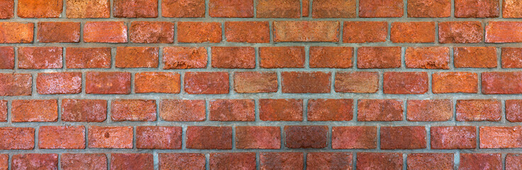 Obraz premium Brick wall of red color, wide panorama of masonry.Red brick wall texture grunge background.