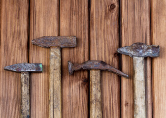 Top view of different old grungy shabby hammers on wooden background