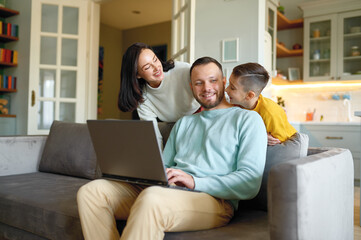 Fototapeta premium Father working online and family asking for attention