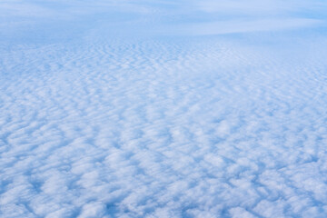 Obraz premium The view from the plane window of dense curly clouds and the blue stratosphere. Cloudscape. Blue sky and white cloud