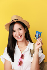 Traveler tourist asian woman hold credit bank card isolated on yellow background