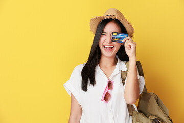 Traveler tourist asian woman hold credit bank card isolated on yellow background