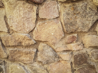 close up. a fragment of an old wall made of natural stone