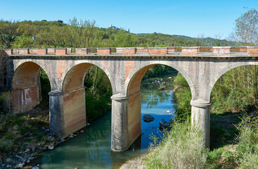 Fototapeta na wymiar Old stone transport bridge in Tuscan countryside