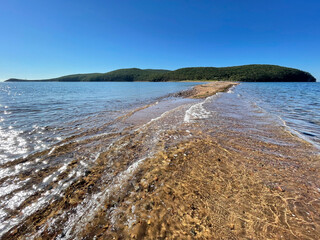 The spit between Russkiy and Shkota islands in sunny autumn day. Russia, Vladivostok