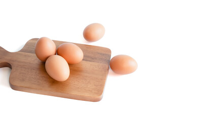 fresh organic chicken eggs. on brown cutting board,