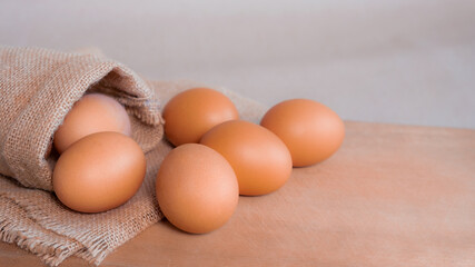 fresh organic chicken eggs. on sack and brown wooden board,