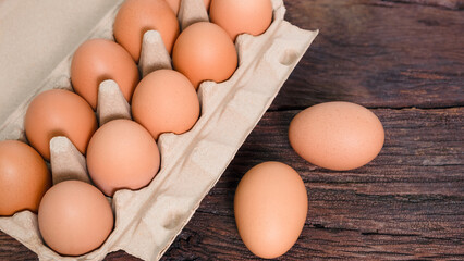 Open eggs box with fresh brown eggs on brown wooden board, Fresh organic chicken eggs in carton box.