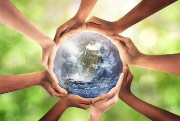 Conceptual symbol of multiracial human hands surrounding the Earth globe. Unity, world peace, humanity concept. World environment day- Earth Day concept. Elements of this image furnished by NASA.