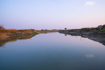 Arial View Canal with green grass and vegetation reflected in the water nearby Padma river in Bangladesh