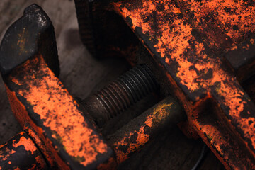 Old vintage vise covered with orange paint