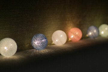 Light bulbs in the night. Celebration decoration. Sparkling bulbs. Shiny background. Glitter decor in night. Glowing garland in dark room. 