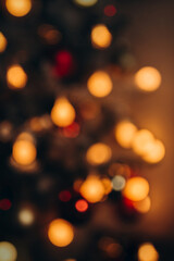 Warm golden lights of christmas tree blurred bokeh on dark background.