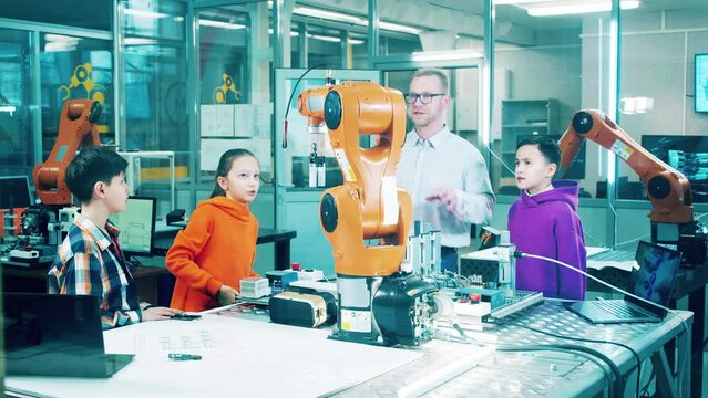 Teacher explaining robotics to children. Technology, school education concept.