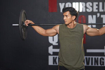young athletic man exercising with barbell in the gym