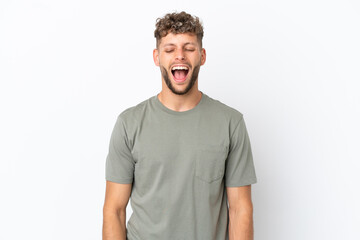 Obraz premium Young caucasian handsome man isolated on white background shouting to the front with mouth wide open