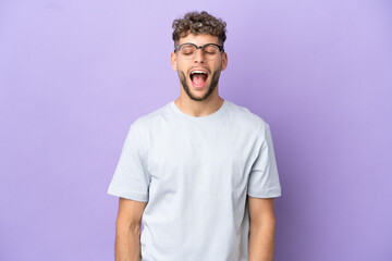 Delivery caucasian man isolated on purple background shouting to the front with mouth wide open