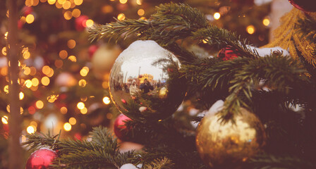 Fototapeta na wymiar Banner photo gold and red ball decorated christmas tree pine on blurred background bokeh sun light