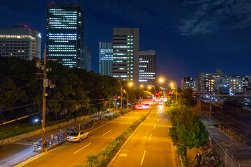 高層ビルを背景にした夜の幹線道路