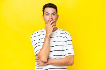 Young handsome man over isolated yellow background surprised and shocked while looking right