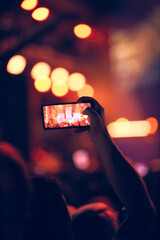 Fototapeta na wymiar Person holding modern smartphone on a concert.